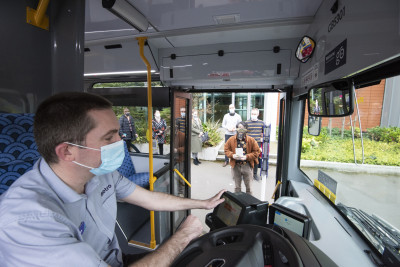 Bus driver wearing a mask stopped at a bus stop